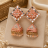 Close-up of designer peach floral jhumka earrings with mirror work, crystal detailing and pearl bead tassels.