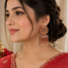 Traditional gold finish earrings with amber tone leaf detailing