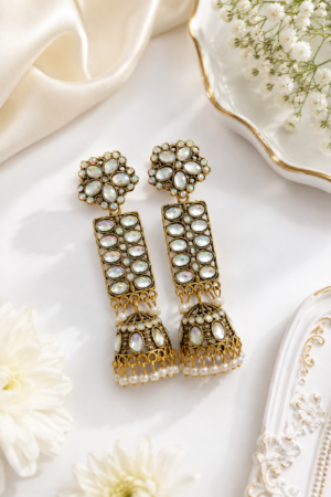 Elegant long jhumka earrings with gold-tone detailing and white accents. Gold finish long jhumka earrings with white stone detailing