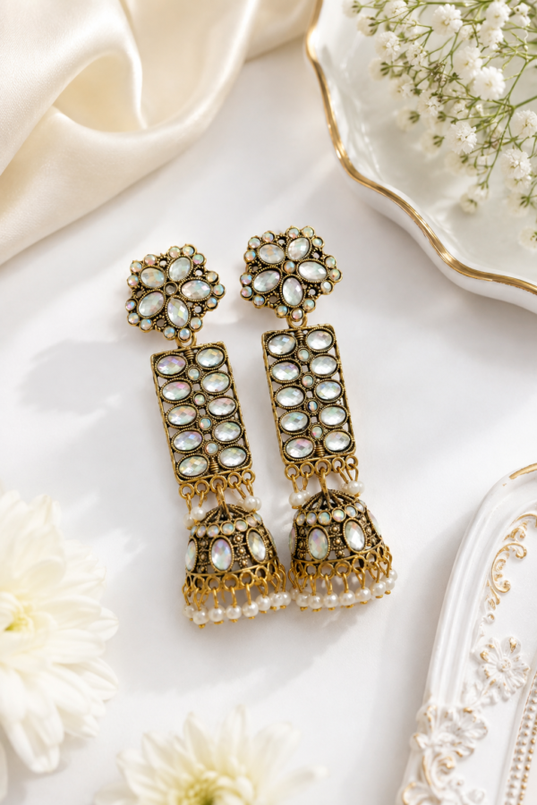 Elegant long jhumka earrings with gold-tone detailing and white accents. Gold finish long jhumka earrings with white stone detailing
