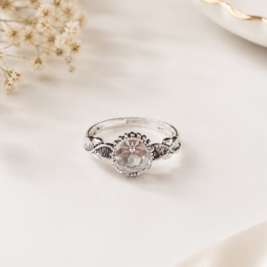 Silver tone clear stone ring with round faceted centre