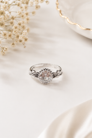 Silver tone clear stone ring with round faceted centre